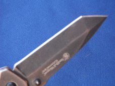 Smith & Wesson Folding knife CK404 & 1975 Smith & Wesson 'The Hostiles' Brass Belt Buckle. Smith & Wesson Folding knife CK404 & 1975 Smith & Wesson 'The Hostiles' Brass Belt Buckle.