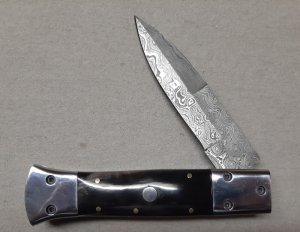 Hand made damascus switchblade with buffalo horn handles.