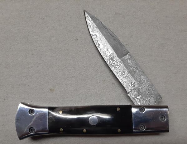 Hand made damascus switchblade with buffalo horn handles.