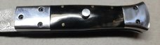 Hand made damascus switchblade with buffalo horn handles.