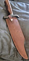 Burnished Stainless Steel Bowie knife with leather sheath.