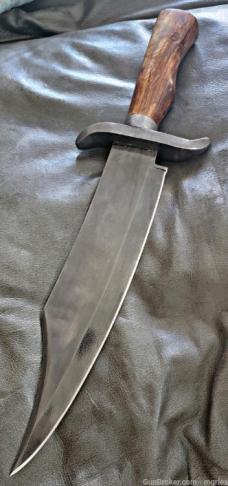 Burnished Stainless Steel Bowie knife with leather sheath.