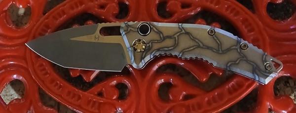 HERETIC MEDUSA AUTO TANTO BATTLE WORN BRONZE W/FLAMED TITANIUM HANDLES.