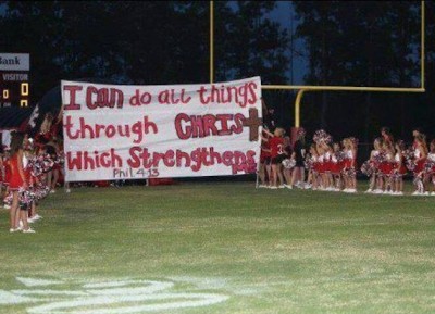 Kountze-cheerleaders-hold-up-one-of-their-biblically-related-signs-Facebook.jpg