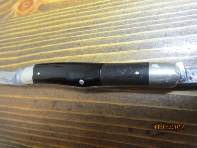 a somewhat cheesy epoxy handle patch I did. I added ebony sanding dust to epoxy and did this patch. When I got the knife off ebay, someone had used a cream colored epoxy to do a prior patch, which I removed. I don't really like my patch job, but in person it is much less noticeable than it is here.