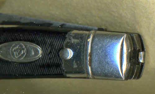 Note the tab of the shell handle half as it bends into slot in the knife frame.
