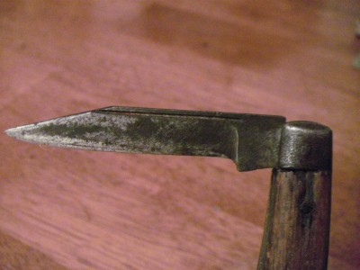 This blade has a thumb pull cut all the way across the top of the blade. The main blade does not go all the way, and has a bevel where it stops.
