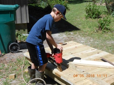 Older brother nailing the 2X6 floor boards