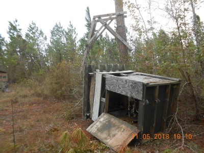 Our old shooting house that had survived more than 20 years.  Notice the ladder and platform in the background, against the pine and the trailer beyond it.  There is a window sill in that stand that probably has at least 35 notches in it.  I hadn't hunted from this stand since the 2013-14 season because of joint replacements.