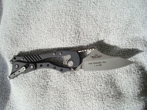 This is a first production run knife by Kershaw called the E.T. for External Toggle. The handle has a knee joint that opens and closes the knife. You push on the small knob at the end of the knife and it opens or closes the blade.  on the back of the blade is a latch that can be uses as a carabiner to clip it to a belt loop.
