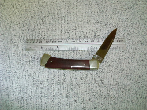 This opens like a standard lockback knife but instead of the lock release being at a notch in the spine, you push up on the tail of the knife to release the blade.