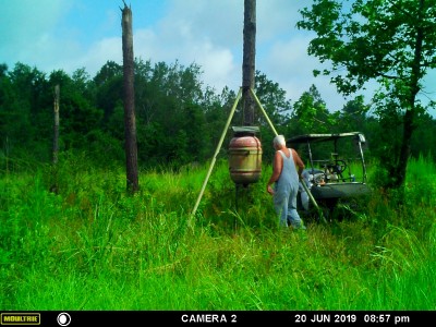 The old man fixin' to refill the feeder with corn.