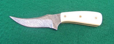 This is the two sides of a mini Sharpfinger. It is Firestorm Damascus 1095 carbon steel and 15N20l steel made by Grand Leavitt in Idaho.