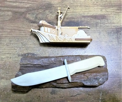 Whale bone knife displayed on petrified wood