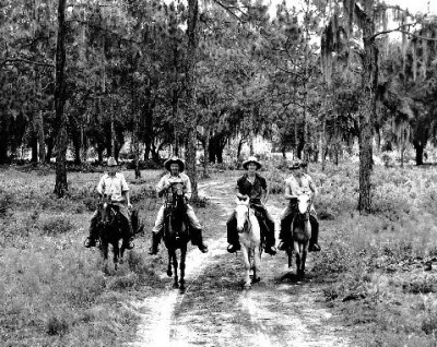 Grandpa is on the light-colored horse.