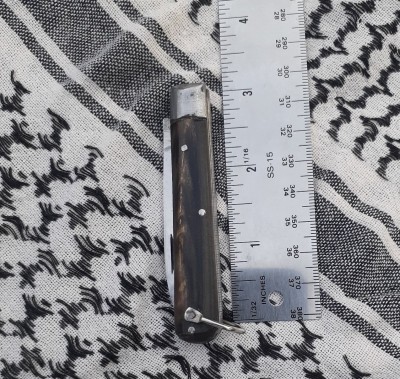 Brown horn scales (goat, I presume), steel bolsters, steel blade.