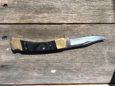 Black micarta Buck 110 in the back pocket
