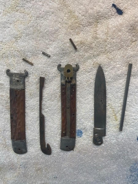 Disassembled knife. Straight piece of metal is the spring “blank”.